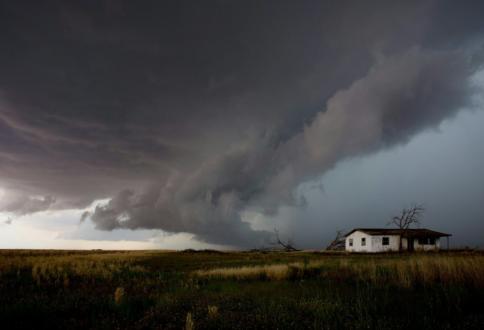 A storm cloud building over a small house